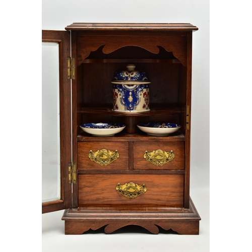 208 - A LATE VICTORIAN OAK CASED SMOKERS CABINET, the bevel edged glazed door opening to reveal a pipe rac... 