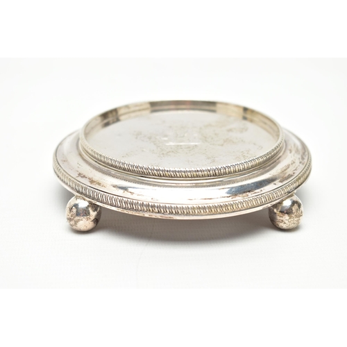 110 - A GEORGE III CIRCULAR SILVER STAND, raised gadrooned rim with engraved crest to the centre, the lowe... 