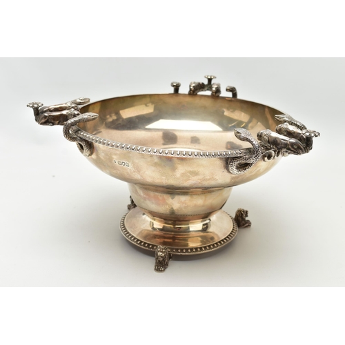 65 - A GEORGE V SILVER PEDESTAL BOWL, with three cast handles, each formed of two serpents and two lion d... 