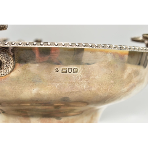 65 - A GEORGE V SILVER PEDESTAL BOWL, with three cast handles, each formed of two serpents and two lion d... 