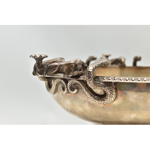 65 - A GEORGE V SILVER PEDESTAL BOWL, with three cast handles, each formed of two serpents and two lion d... 