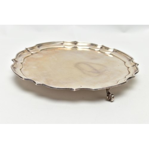 66 - AN ELIZABETH II SILVER SALVER OF CIRCULAR FORM WITH PIE CRUST RIM, on three scrolled feet, makers Pi... 