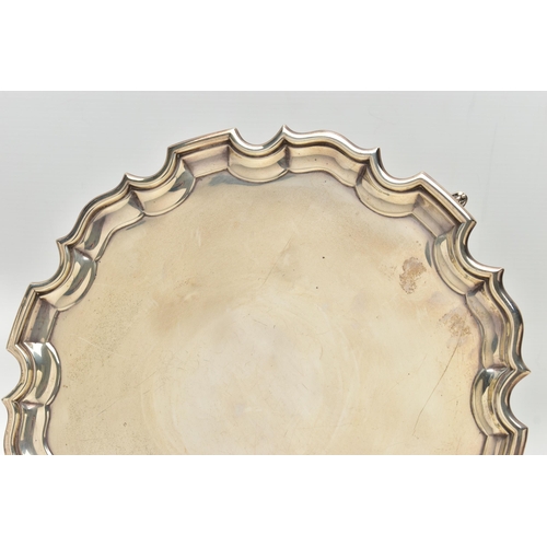 75 - A GEORGE V SILVER SALVER OF CIRCULAR FORM WITH PIE CRUST RIM, plain surface, on three short cabriole... 