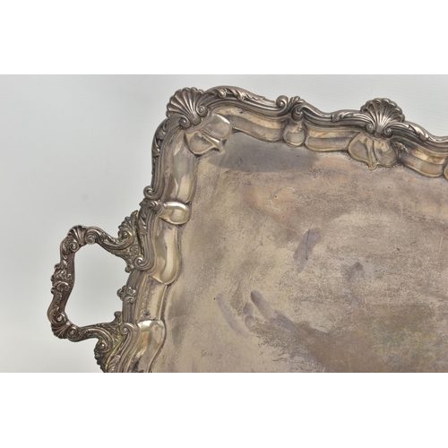 76 - AN EDWARDIAN SILVER TWIN HANDLED TRAY OF RECTANGULAR FORM WITH PIE CRUST AND SHELL RIMS, plain surfa... 