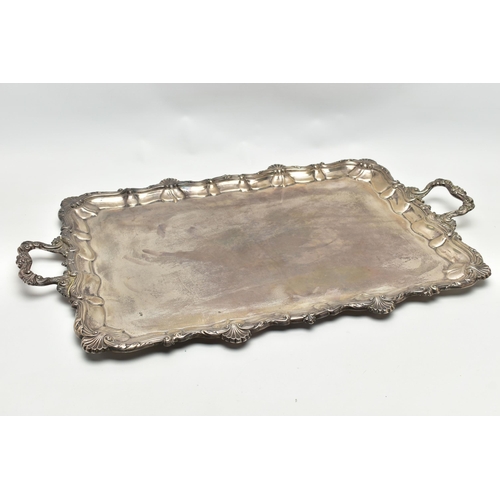 76 - AN EDWARDIAN SILVER TWIN HANDLED TRAY OF RECTANGULAR FORM WITH PIE CRUST AND SHELL RIMS, plain surfa... 