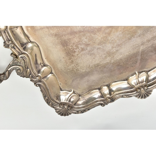 76 - AN EDWARDIAN SILVER TWIN HANDLED TRAY OF RECTANGULAR FORM WITH PIE CRUST AND SHELL RIMS, plain surfa... 