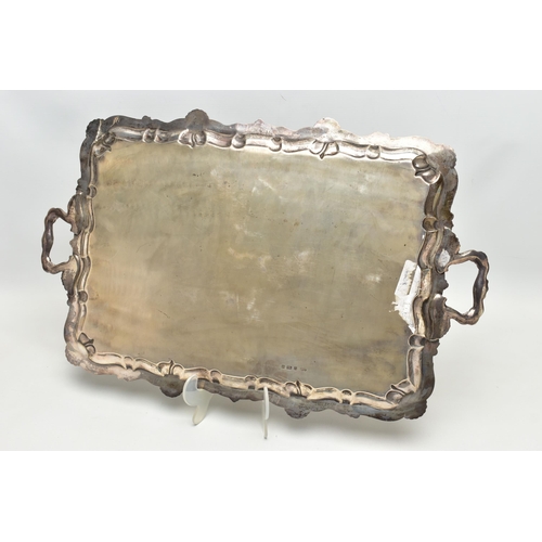 76 - AN EDWARDIAN SILVER TWIN HANDLED TRAY OF RECTANGULAR FORM WITH PIE CRUST AND SHELL RIMS, plain surfa... 