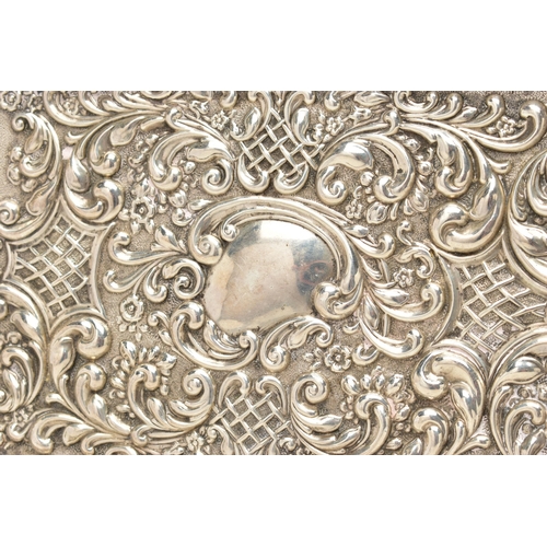 86 - AN EDWARDIAN SILVER TRAY, rectangular form, scalloped edges, embossed with scrolling foliage and flo... 