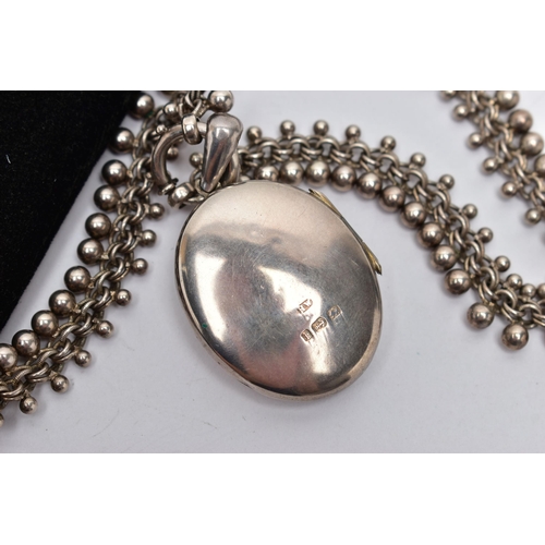 28 - A LATE 19TH CENTURY LOCKET AND CHAIN, oval form silver locket detailed with a belt and buckle design... 
