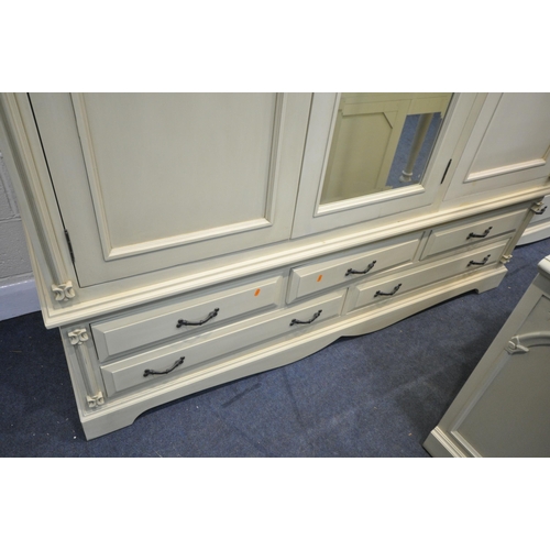 1227 - A GOOD QUALITY CREAM FRENCH BEDROOM SUITE, comprising a triple door wardrobe, above five drawers, wi... 