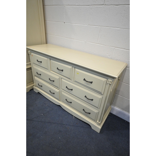 1227 - A GOOD QUALITY CREAM FRENCH BEDROOM SUITE, comprising a triple door wardrobe, above five drawers, wi... 