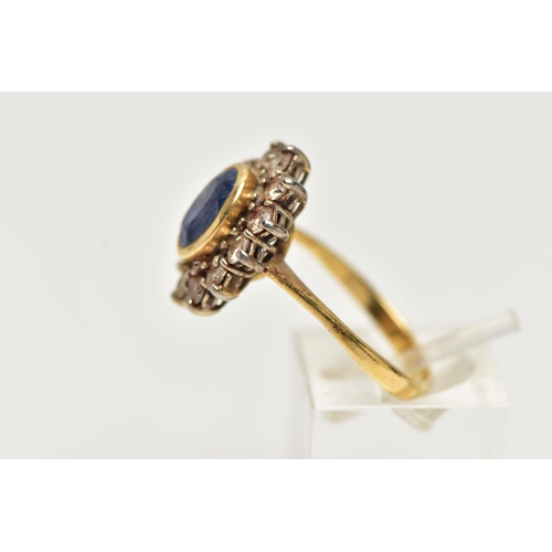 24 - A SAPPHIRE AND DIAMOND CLUSTER RING, oval cut blue sapphire set within a yellow gold bezel mount, wi... 