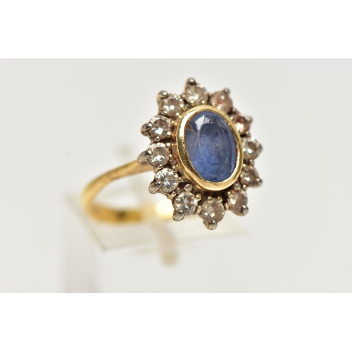 24 - A SAPPHIRE AND DIAMOND CLUSTER RING, oval cut blue sapphire set within a yellow gold bezel mount, wi... 