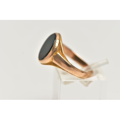 28 - AN EARLY 20TH CENTURY 15CT GOLD SIGNET RING, inlay set with oval cut bloodstone, leading on to a tap... 