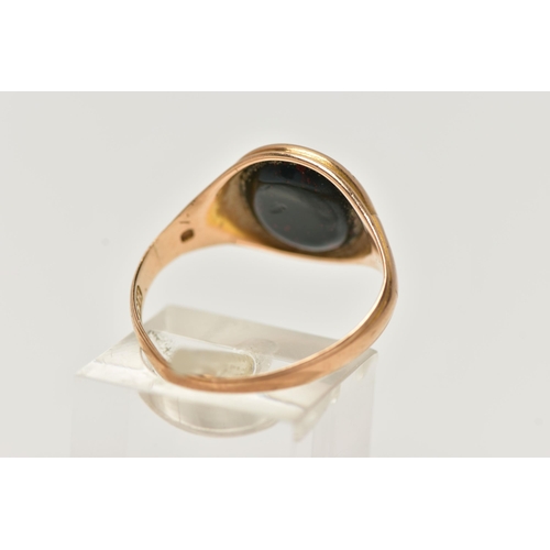 28 - AN EARLY 20TH CENTURY 15CT GOLD SIGNET RING, inlay set with oval cut bloodstone, leading on to a tap... 