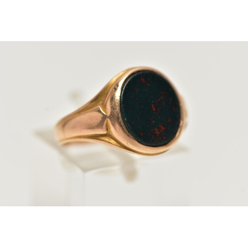 28 - AN EARLY 20TH CENTURY 15CT GOLD SIGNET RING, inlay set with oval cut bloodstone, leading on to a tap... 