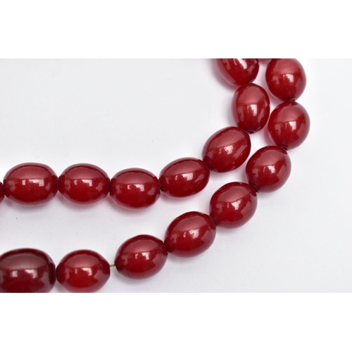 45 - A GRADUATING BAKELITE BEAD NECKLACE, oval cherry amber colour beads, graduating in size, largest mea... 