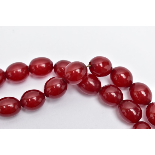 45 - A GRADUATING BAKELITE BEAD NECKLACE, oval cherry amber colour beads, graduating in size, largest mea... 