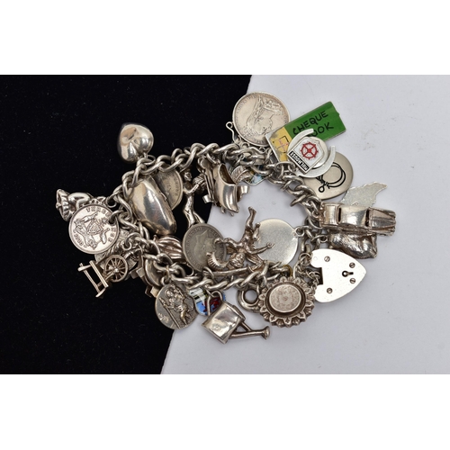 5 - A WHITE METAL CHARM BRACELET, curb link bracelet, links unmarked, fitted with thirty four charms, in... 