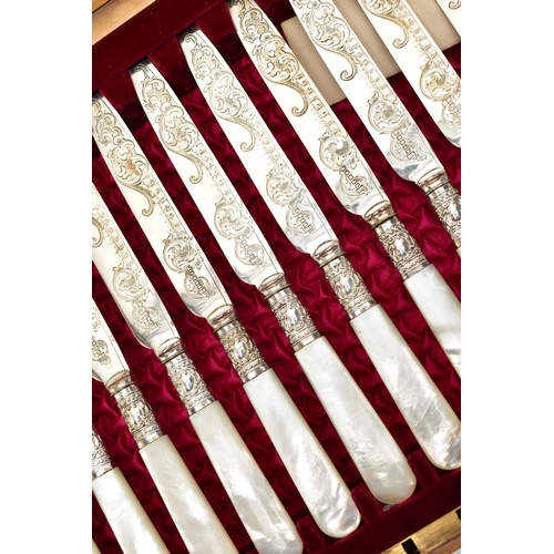 61 - A CASED SET OF TWELVE DESSERT KNIVES AND FORKS, each EPNS blade is decorated with a floral pattern, ... 