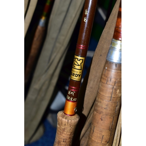 345 - A CAST IRON LECTERN WITH A COLLECTION OF ELEVEN VINTAGE FISHING RODS, comprising Bruce & Walker hand... 