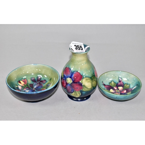 355 - THREE PIECES OF MOORCROFT POTTERY, comprising a Clematis pattern vase height 11cm, a Spring Flowers ... 