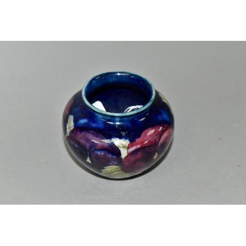 386 - A SMALL MOORCROFT POTTERY BALUSTER VASE, decorated with tube lined purple Pansy pattern on a dark bl... 