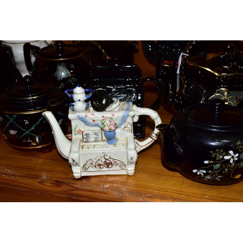 412 - A COLLECTION OF EARLY 20TH CENTURY TEAPOTS, comprising a Sadler hand painted floral design on a blac... 