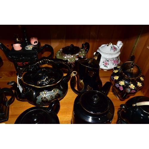 412 - A COLLECTION OF EARLY 20TH CENTURY TEAPOTS, comprising a Sadler hand painted floral design on a blac... 