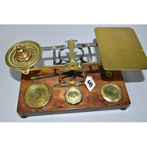 445 - A SET OF BRASS POSTAL SCALES WITH A COMPLETE SET OF BRASS WEIGHTS, mounted to a wooden plinth