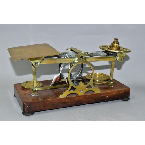 445 - A SET OF BRASS POSTAL SCALES WITH A COMPLETE SET OF BRASS WEIGHTS, mounted to a wooden plinth