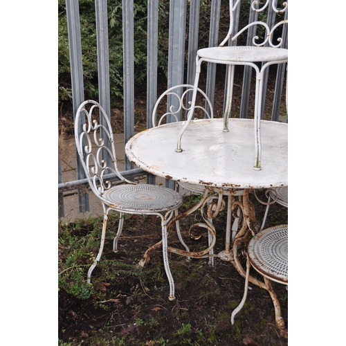 1002 - A WHITE PAINTED METAL GARDEN TABLE 100cm in diameter with scrolled tubular legs and five similar cha... 