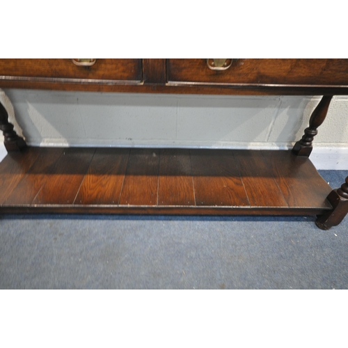 1260 - A REPRODUCTION OAK DRESSER BASE, with two drawers, on turned and block legs, united by an undershelf... 