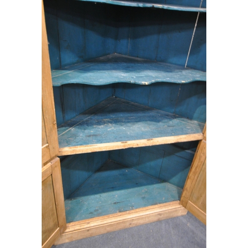 1312 - A LARGE VICTORIAN PINE PANELLED FOUR DOOR CORNER CUPBOARD, enclosing a blue painted interior, and th... 