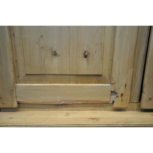 1315 - A FRENCH PINE WARDROBE, with an overhanging cornice, double panelled doors, flanked by half turned p... 