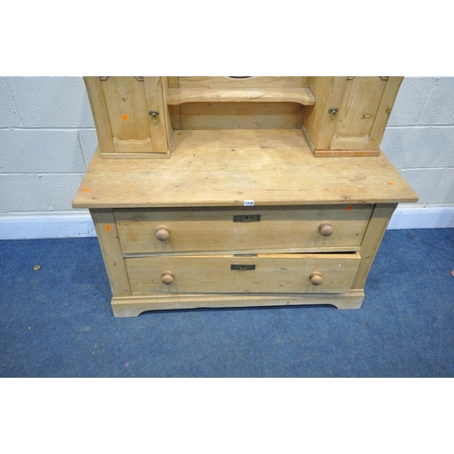 1318 - A PINE DRESSING TABLE, with two panelled cupboards flanking an oval bevelled edge swing mirror, on a... 