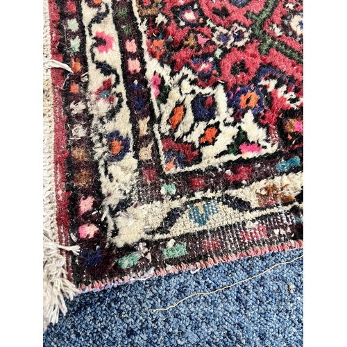 1363 - A 19TH CENTURY PERSIAN HOSSEINABAD CARPET RUNNER, red field, central cream medallion, length 284cm x... 