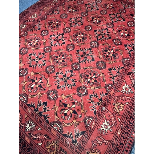 1365 - A LATE 19TH/EARLY 20TH CENTURY RUG, red field within a repeating geometric pattern, and multi strap ... 