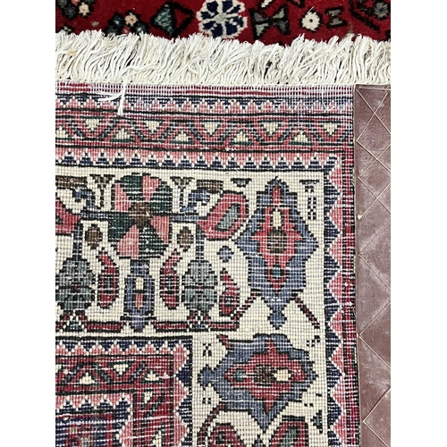 1368 - A 20TH CENTURY IRANIAN ABADEH RUG, typical design with a central medallion, with a central red field... 