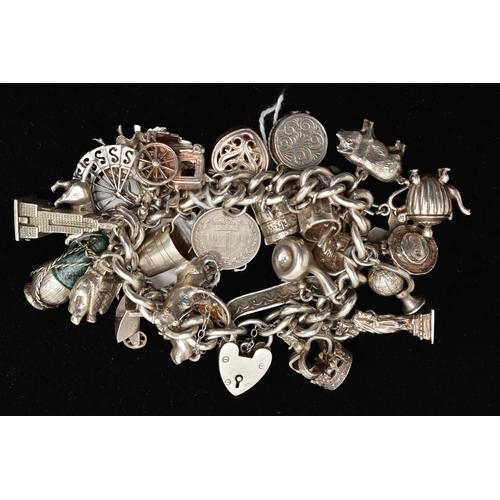 773A - A SILVER AND WHITE METAL CHARM BRACELET,  a silver curb link chain fitted with a heart padlock clasp... 