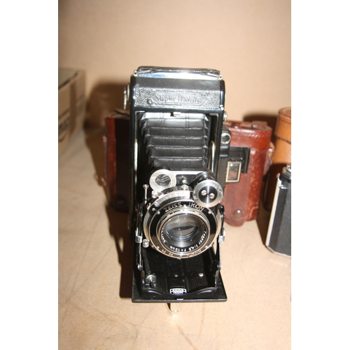 877 - A TRAY CONTAINING FOUR FOLDING CAMERAS including a Zeiss Ikon Super Ikonta 530/15 in leather case, a... 