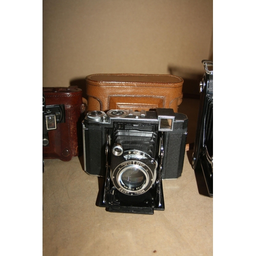 877 - A TRAY CONTAINING FOUR FOLDING CAMERAS including a Zeiss Ikon Super Ikonta 530/15 in leather case, a... 