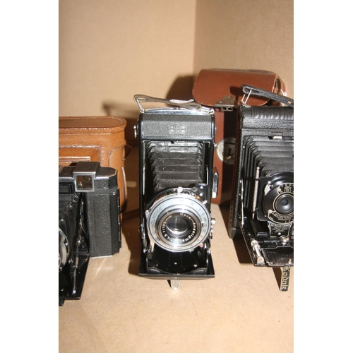 877 - A TRAY CONTAINING FOUR FOLDING CAMERAS including a Zeiss Ikon Super Ikonta 530/15 in leather case, a... 