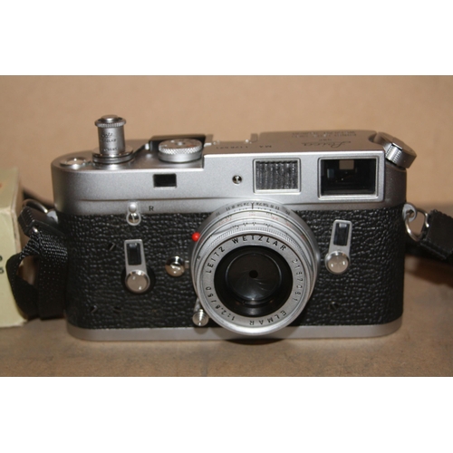 885 - A LEICA M4 FILM CAMERA in chrome Serial No 1176521 fitted with an Elmar 50mm f2.8 lens, two lens cap... 