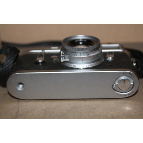 885 - A LEICA M4 FILM CAMERA in chrome Serial No 1176521 fitted with an Elmar 50mm f2.8 lens, two lens cap... 