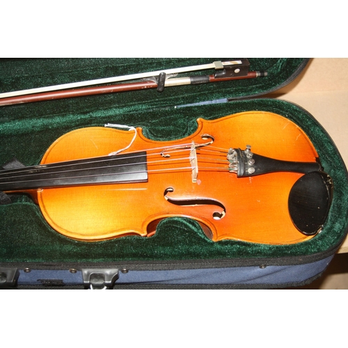 939 - TWO MODERN VIOLINS IN CASES one is a Chinese MV007 the other is unbranded with two bows