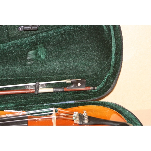 939 - TWO MODERN VIOLINS IN CASES one is a Chinese MV007 the other is unbranded with two bows