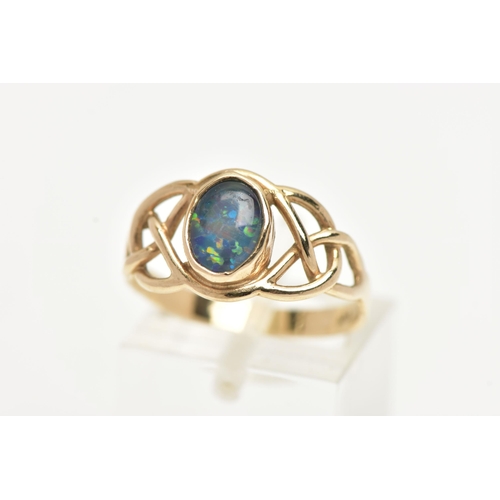 12 - A YELLOW METAL GEMSET RING, a opal triplet collet set in an open work Celtic design yellow metal rin... 