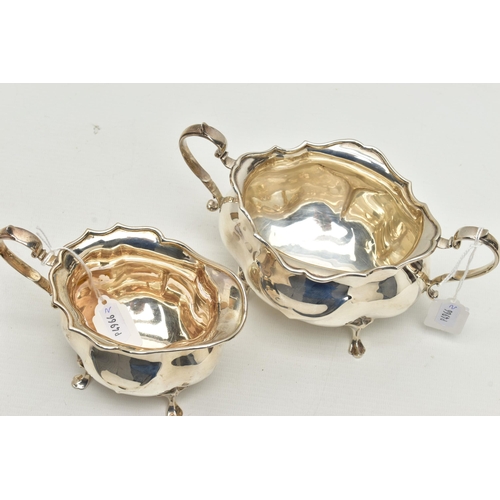 154 - AN EDWARDIAN SILVER TWIN HANDLED SUGAR BOWL AND MILK JUG OF BOMBÉ FORM, on four cabriole legs, maker... 