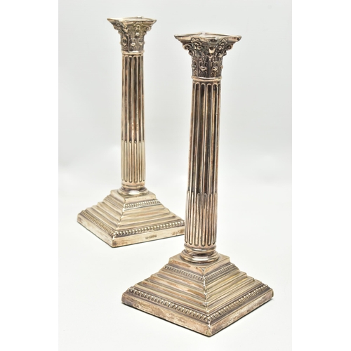 156 - A PAIR OF GEORGE V SILVER CORINTHIAN COLUMN CANDLESTICKS, fluted and stop reeded columns on stepped ... 